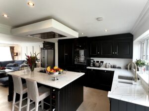 Black Georgian style kitchen with kitchen island and white grain quartz worktops.