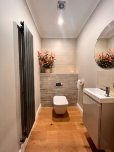 Modern, ground floor WC renovation, with wall mounted cistern and anthracite vertical panel radiators.